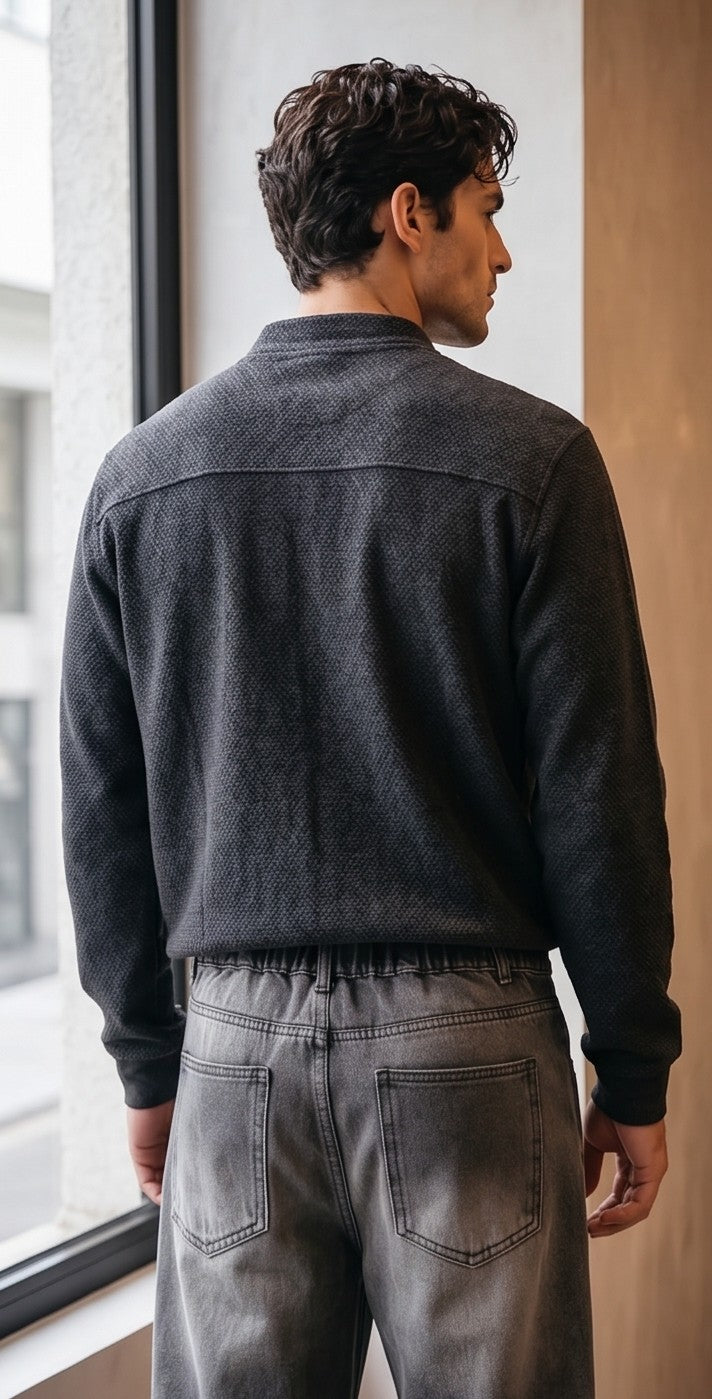 Pantalón vaquero de corte ancho y tiro medio en tono azul claro con efecto desgastado, costuras verticales decorativas en las piernas y detalle de cintura elástica en la parte trasera.