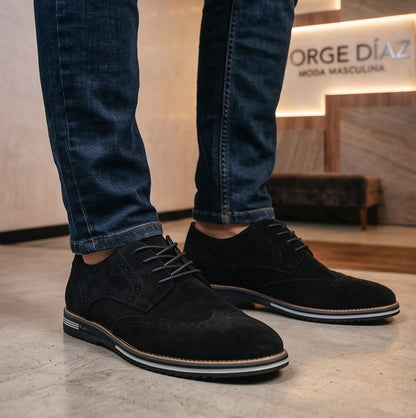 Zapatos casuales de estilo brogue para hombre, disponibles en cuatro colores: marrón, azul marino, negro y marrón oscuro. Cuentan con un diseño de cordones, detalles decorativos de perforaciones y una suela de goma blanca en contraste.
