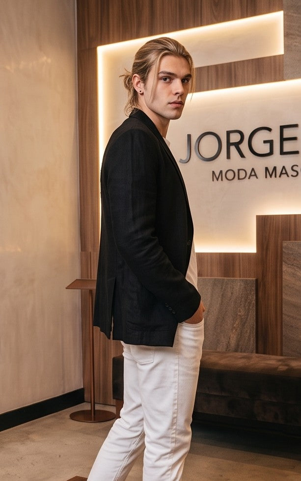 blazer de lino desestructurado para hombre. La prenda, de corte casual y ligero, muestra la textura granulada natural del lino. Tiene solapas de muesca, un cierre de dos botones frontales y dos grandes bolsillos de parche aplicados en la cintura.