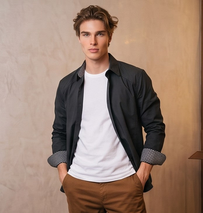 Camisa casual de hombre confeccionada en algodón liso, de corte holgado y manga larga, con cuello de solapa camisero abotonado al frente y detalle estampado en el borde interno de los puños y cuello, mostrada de frente y de espaldas en tonos café rojizo y gris oscuro azulado.