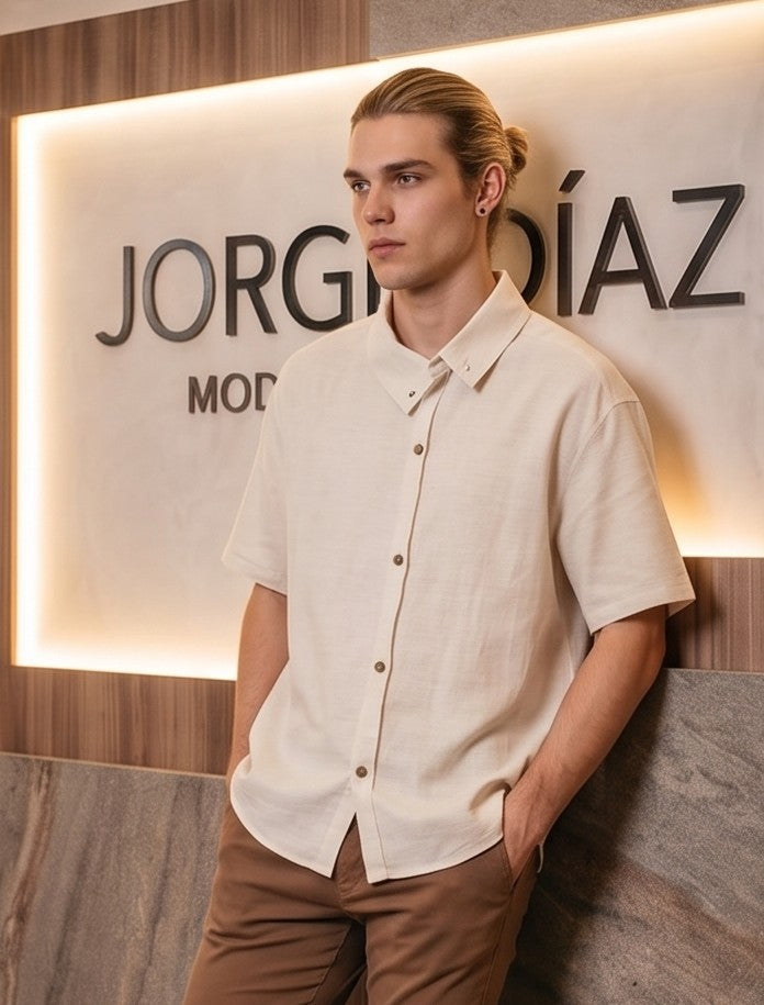 Camisa casual de manga corta holgada para hombre con textura ligera tipo lino, cuello asimétrico y botones frontales, disponible en color negro y beige arena sobre fondo neutro