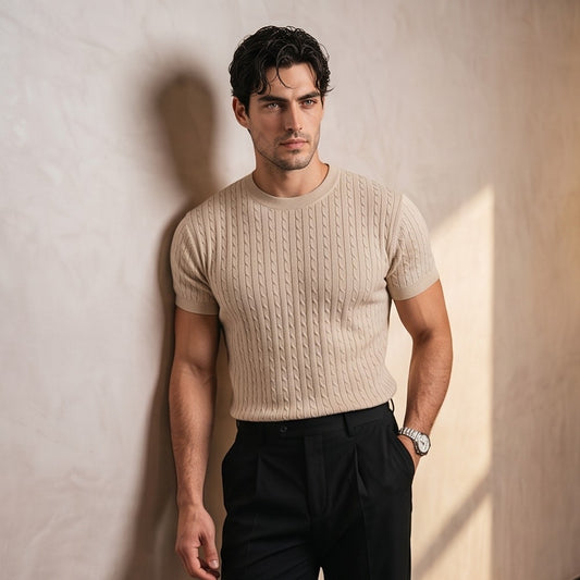 Hombre luciendo una camiseta de punto trenzado de manga corta y cuello redondo. Diseño de textura en relieve con ajuste entallado que resalta la figura masculina. Prenda de estilo smart-casual, disponible en colores neutros y versátiles (beige, blanco y negro), combinada con diferentes pantalones para un look moderno y elegante