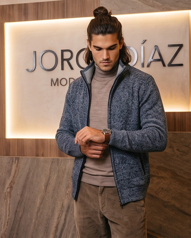 Cárdigan de punto grueso para hombre con cuello alto, cierre de cremallera metálica y forro interior de cuadros escoceses, disponible en negro, gris oscuro jaspeado, azul jaspeado y rojo burdeos jaspeado, exhibido en una tienda de moda masculina