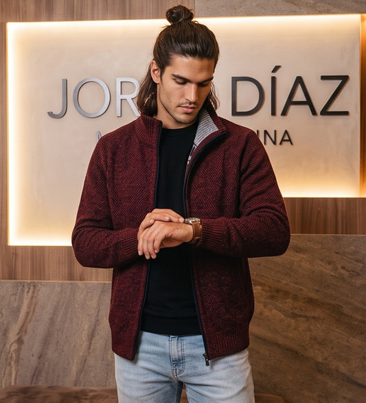Cárdigan de punto grueso para hombre con cuello alto, cierre de cremallera metálica y forro interior de cuadros escoceses, disponible en negro, gris oscuro jaspeado, azul jaspeado y rojo burdeos jaspeado, exhibido en una tienda de moda masculina