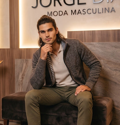 Cárdigan de punto grueso para hombre con cuello alto, cierre de cremallera metálica y forro interior de cuadros escoceses, disponible en negro, gris oscuro jaspeado, azul jaspeado y rojo burdeos jaspeado, exhibido en una tienda de moda masculina