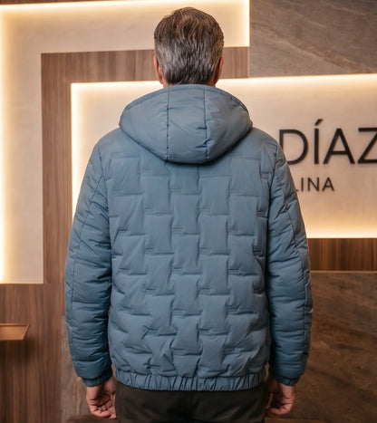 Chaqueta acolchada para hombre de corte holgado con capucha, cremallera frontal y textura geométrica termosellada, disponible en tonos beige crema, azul grisáceo y negro