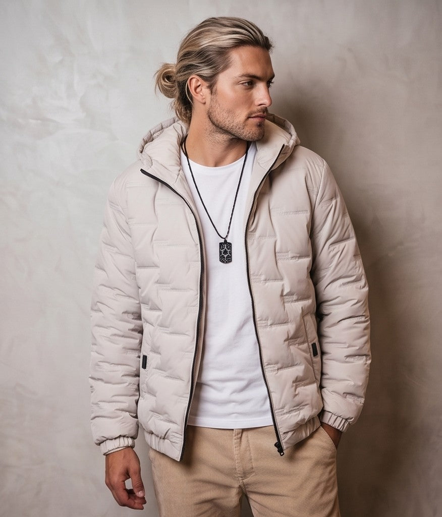 Chaqueta acolchada para hombre de corte holgado con capucha, cremallera frontal y textura geométrica termosellada, disponible en tonos beige crema, azul grisáceo y negro