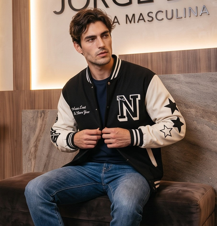 Chaqueta varsity de béisbol para hombre estilo universitario retro con mangas en contraste blanco, parche frontal de la letra N bordada y detalles de estrellas en las mangas, disponible en color negro, azul y verde