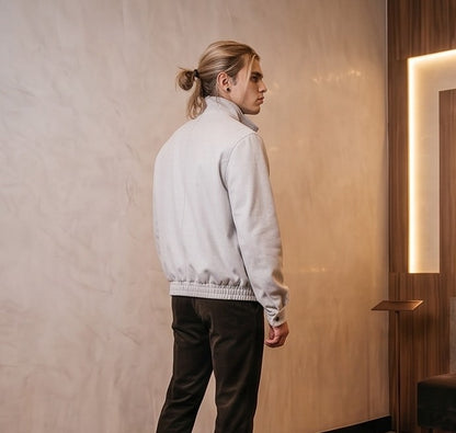 Chaqueta bomber de corte relajado para hombre en color liso, confeccionada en tejido de mezcla de algodón, con cierre frontal de cremallera oculta por solapa, cuello alto envolvente con tira de abotonado doble, bolsillos diagonales con solapa y acabados elásticos en cintura y puños