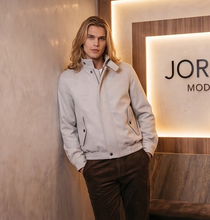 Chaqueta bomber de corte relajado para hombre en color liso, confeccionada en tejido de mezcla de algodón, con cierre frontal de cremallera oculta por solapa, cuello alto envolvente con tira de abotonado doble, bolsillos diagonales con solapa y acabados elásticos en cintura y puños
