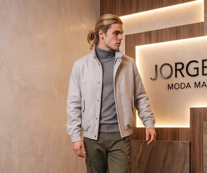 Chaqueta bomber de corte relajado para hombre en color liso, confeccionada en tejido de mezcla de algodón, con cierre frontal de cremallera oculta por solapa, cuello alto envolvente con tira de abotonado doble, bolsillos diagonales con solapa y acabados elásticos en cintura y puños