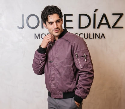Chaqueta bomber de corte holgado para hombre en tono monocolor con acabado lavado disponible en morado ciruela y gris grafito oscuro. Destaca por mangas largas fruncidas tipo stacked, bolsillo utilitario con cremallera en el brazo, cierre central de cremallera con broches metálicos delanteros y cuello y puños elásticos acanalados en negro