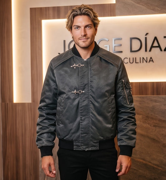 Chaqueta bomber de corte holgado para hombre en tono monocolor con acabado lavado disponible en morado ciruela y gris grafito oscuro. Destaca por mangas largas fruncidas tipo stacked, bolsillo utilitario con cremallera en el brazo, cierre central de cremallera con broches metálicos delanteros y cuello y puños elásticos acanalados en negro