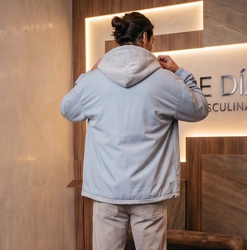 Chaqueta urbana estilo bomber oversize con capucha y forro interior a contraste efecto dos piezas con cierre de cremallera frontal, cuello camisero con solapa, puños elásticos y bajo recto. Disponible en combinaciones de color negro con azul, beige caqui con azul y celeste con gris.