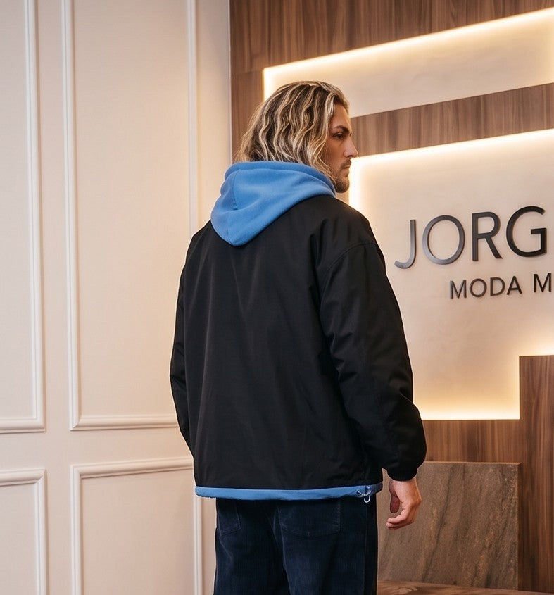 Chaqueta urbana estilo bomber oversize con capucha y forro interior a contraste efecto dos piezas con cierre de cremallera frontal, cuello camisero con solapa, puños elásticos y bajo recto. Disponible en combinaciones de color negro con azul, beige caqui con azul y celeste con gris.