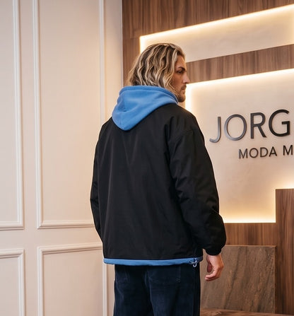 Chaqueta urbana estilo bomber oversize con capucha y forro interior a contraste efecto dos piezas con cierre de cremallera frontal, cuello camisero con solapa, puños elásticos y bajo recto. Disponible en combinaciones de color negro con azul, beige caqui con azul y celeste con gris.