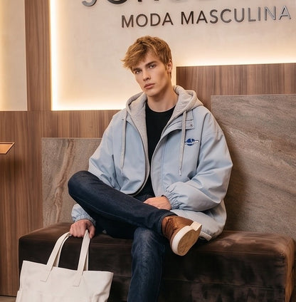 Chaqueta urbana estilo bomber oversize con capucha y forro interior a contraste efecto dos piezas con cierre de cremallera frontal, cuello camisero con solapa, puños elásticos y bajo recto. Disponible en combinaciones de color negro con azul, beige caqui con azul y celeste con gris.