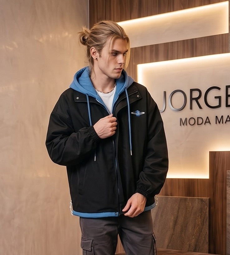 Chaqueta urbana estilo bomber oversize con capucha y forro interior a contraste efecto dos piezas con cierre de cremallera frontal, cuello camisero con solapa, puños elásticos y bajo recto. Disponible en combinaciones de color negro con azul, beige caqui con azul y celeste con gris.