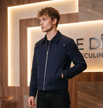Chaqueta entallada slim fit para hombre disponible en color negro y azul marino, confeccionada en tejido liso estructurado con cuello camisero, cremallera metálica frontal central, puños con cierre a presión y detalles decorativos de solapa en los hombros sobre fondo de estudio minimalista