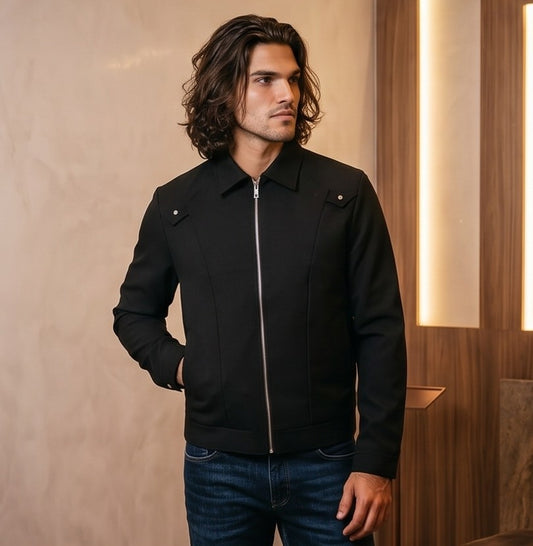 Chaqueta entallada slim fit para hombre disponible en color negro y azul marino, confeccionada en tejido liso estructurado con cuello camisero, cremallera metálica frontal central, puños con cierre a presión y detalles decorativos de solapa en los hombros sobre fondo de estudio minimalista