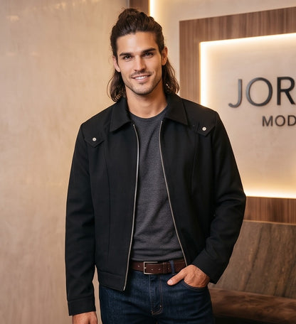 Chaqueta entallada slim fit para hombre disponible en color negro y azul marino, confeccionada en tejido liso estructurado con cuello camisero, cremallera metálica frontal central, puños con cierre a presión y detalles decorativos de solapa en los hombros sobre fondo de estudio minimalista