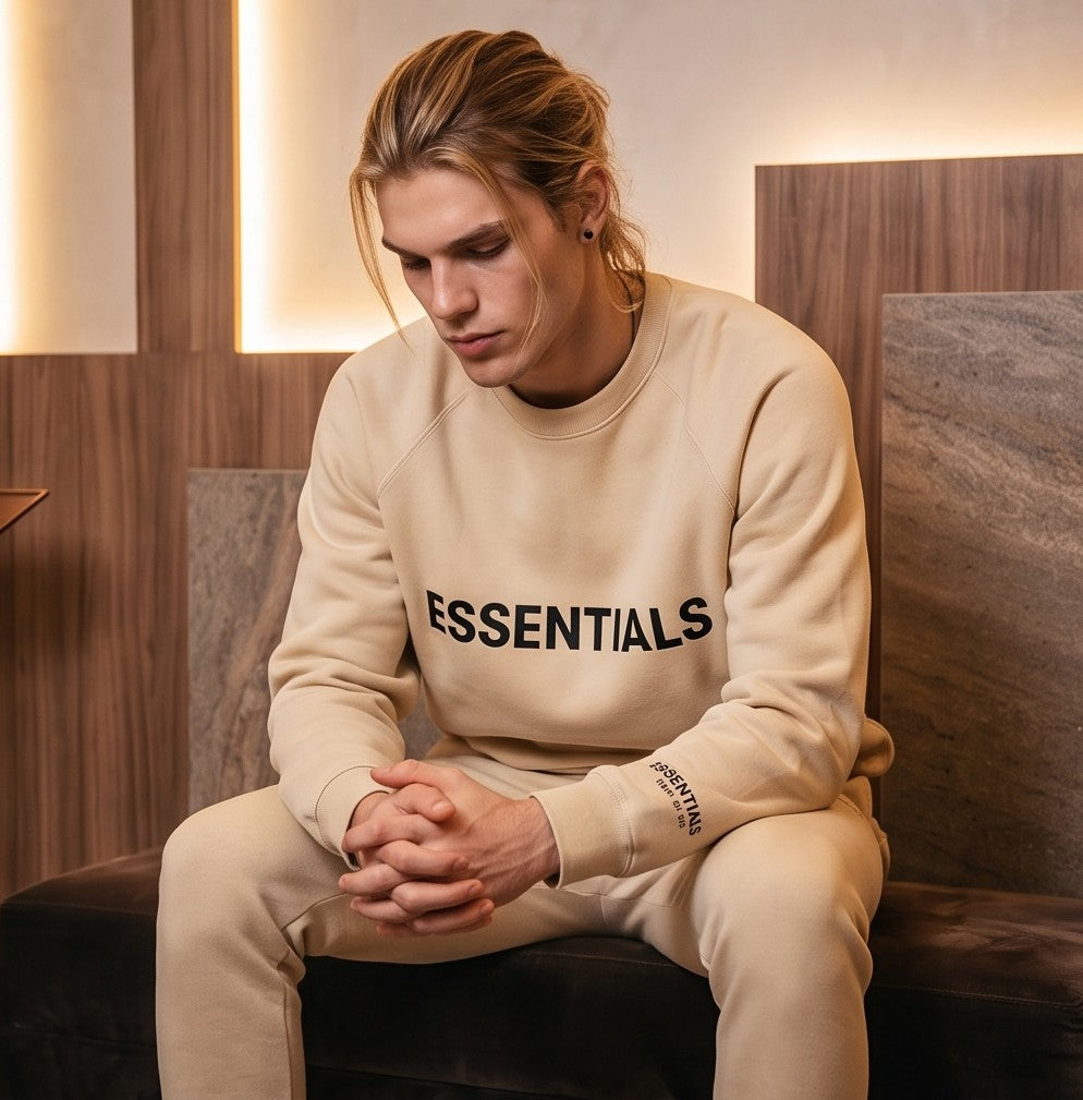 Conjunto urbano de dos piezas estilo Essentials en cinco colores (negro, gris jaspeado, beige, blanco y negro mate): sudadera de manga larga con cuello redondo y pantalón jogger a juego con estampado tipográfico minimalista en pecho, manga y pierna