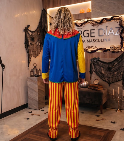 Disfraz de payaso clásico para hombre en tejido multicolor con camisa azul y amarilla de parches geométricos, cuello fruncido rojo con pompones y pantalón holgado de rayas verticales amarillas y rojas
