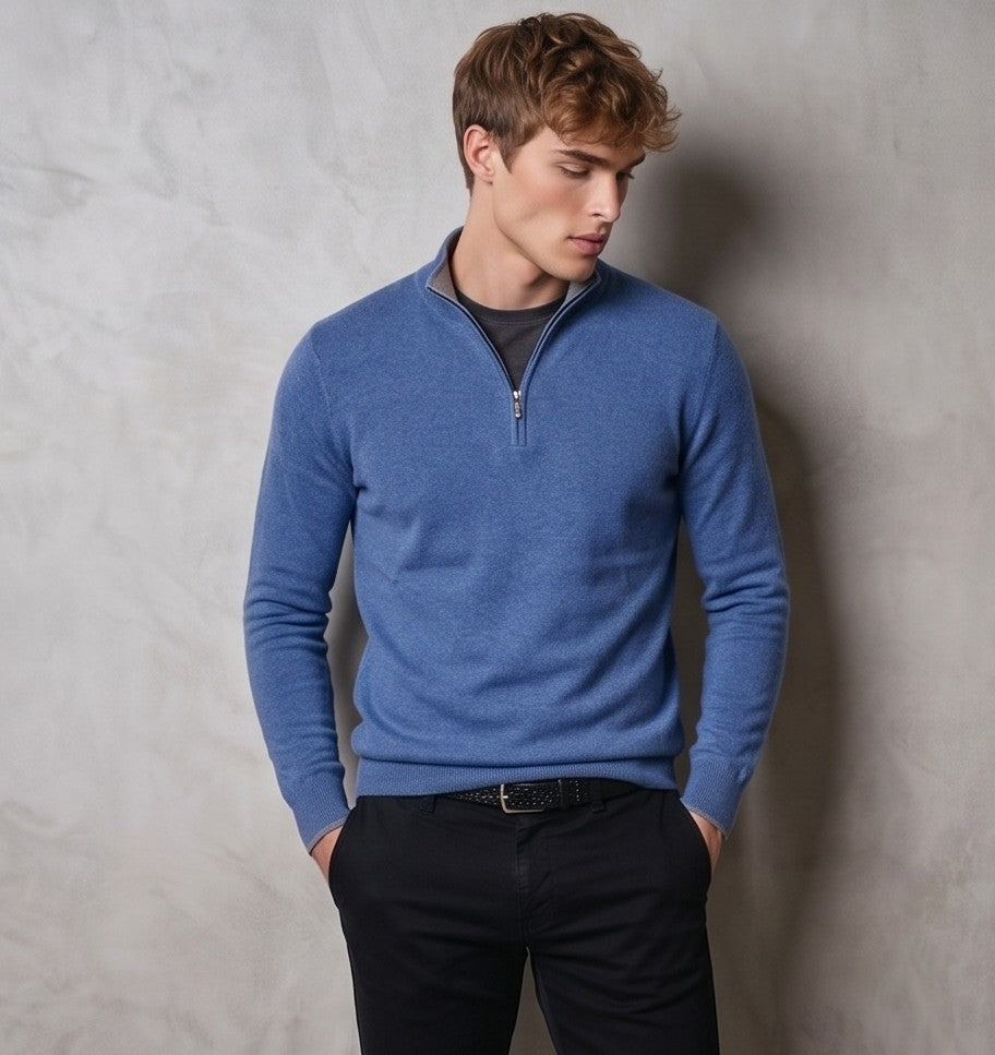 jersey de punto premium para hombre. Presenta un diseño clásico de cuello alto con media cremallera metálica central. La prenda muestra una textura de micropunto suave y densa, sugiriendo una mezcla de lana y cashmere de alta calidad. El corte es entallado pero cómodo (modern fit), con acabados acanalados en puños, bajo y cuello para un ajuste perfecto. Estilo versátil, ideal para looks casuales elegantes o de oficina