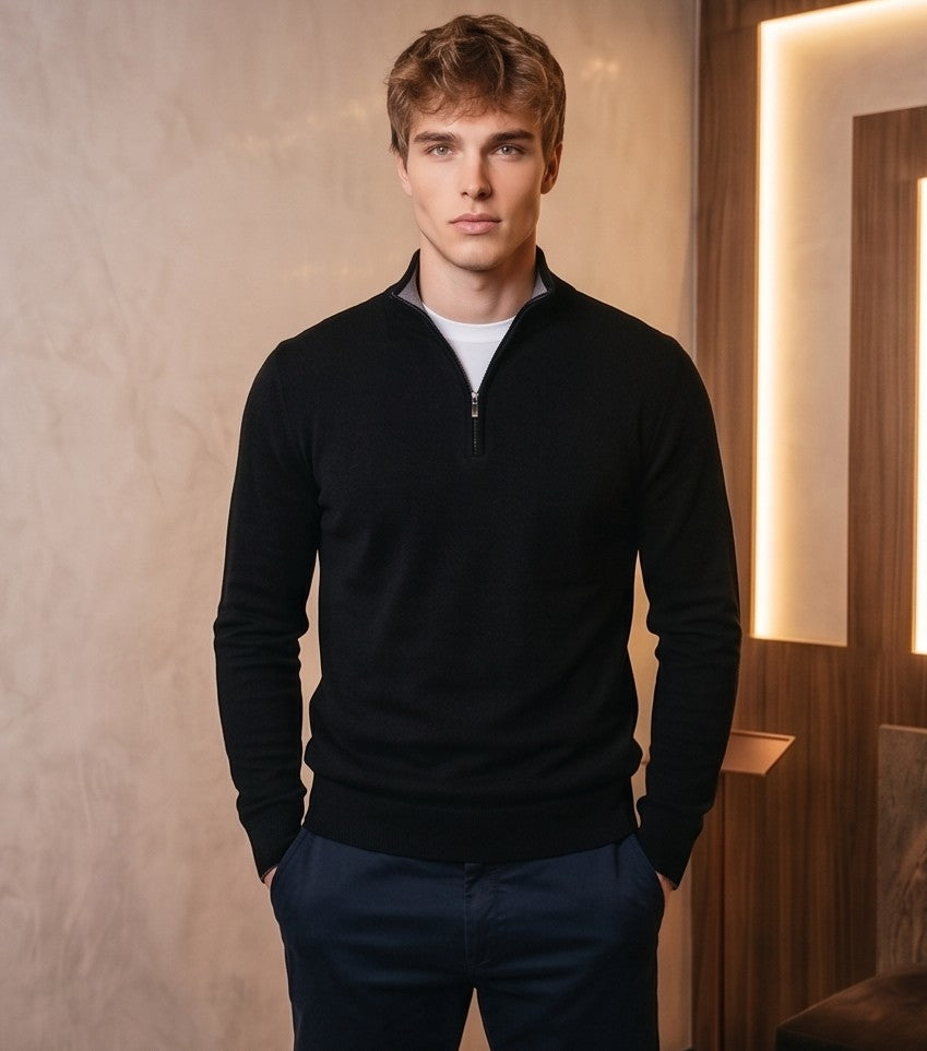 jersey de punto premium para hombre. Presenta un diseño clásico de cuello alto con media cremallera metálica central. La prenda muestra una textura de micropunto suave y densa, sugiriendo una mezcla de lana y cashmere de alta calidad. El corte es entallado pero cómodo (modern fit), con acabados acanalados en puños, bajo y cuello para un ajuste perfecto. Estilo versátil, ideal para looks casuales elegantes o de oficina