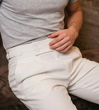 Pantalón de vestir elegante para hombre con pretina ancha estilo Gurkha, cierre de doble botón, pinzas frontales y ajustadores laterales, disponible en colores negro, marrón camel, gris plomo y blanco marfil en tienda Jorge Díaz Moda Masculina.