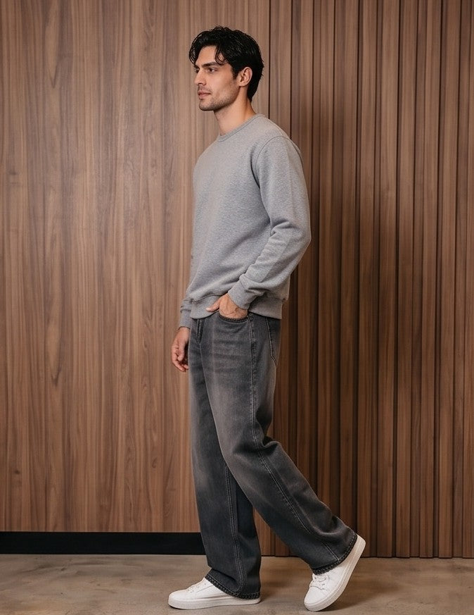 Pantalón vaquero de corte ancho y tiro medio en tono azul claro con efecto desgastado, costuras verticales decorativas en las piernas y detalle de cintura elástica en la parte trasera.