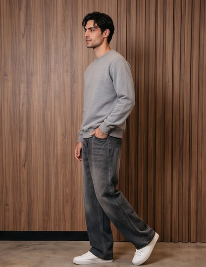 Pantalón vaquero de corte ancho y tiro medio en tono azul claro con efecto desgastado, costuras verticales decorativas en las piernas y detalle de cintura elástica en la parte trasera.