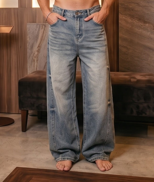 Pantalón vaquero de corte ancho y tiro medio en tono azul claro con efecto desgastado, costuras verticales decorativas en las piernas y detalle de cintura elástica en la parte trasera.