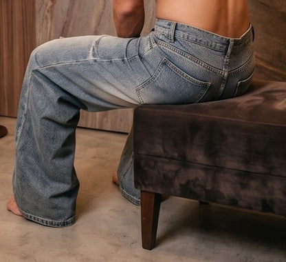 Pantalón vaquero de corte ancho y tiro medio en tono azul claro con efecto desgastado, costuras verticales decorativas en las piernas y detalle de cintura elástica en la parte trasera.