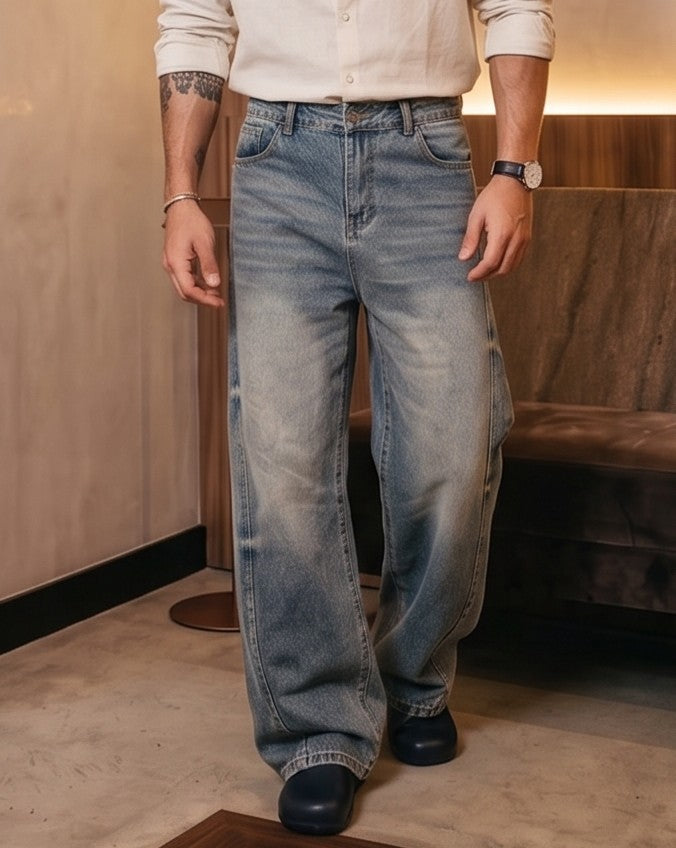 Pantalón vaquero de corte ancho y tiro medio en tono azul claro con efecto desgastado, costuras verticales decorativas en las piernas y detalle de cintura elástica en la parte trasera.