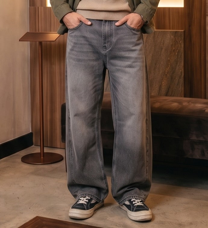 Pantalón vaquero de corte ancho y tiro medio en tono azul claro con efecto desgastado, costuras verticales decorativas en las piernas y detalle de cintura elástica en la parte trasera.