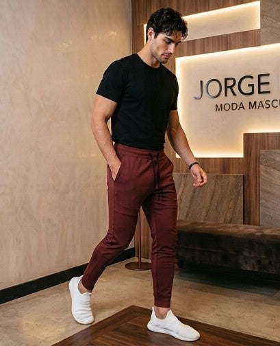 Pantalón jogger deportivo y casual para hombre de corte ajustado tipo slim fit con cintura elástica con cordón ajustable, bolsillos laterales profundos y bolsillo trasero con cremallera termosellada. Disponible en colores verde azulado, negro, blanco y granate.