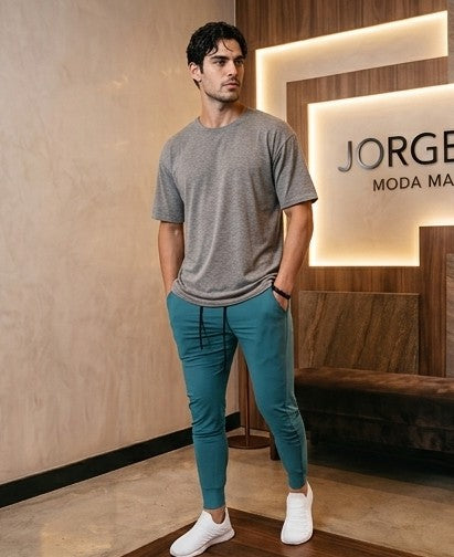 Pantalón jogger deportivo y casual para hombre de corte ajustado tipo slim fit con cintura elástica con cordón ajustable, bolsillos laterales profundos y bolsillo trasero con cremallera termosellada. Disponible en colores verde azulado, negro, blanco y granate.