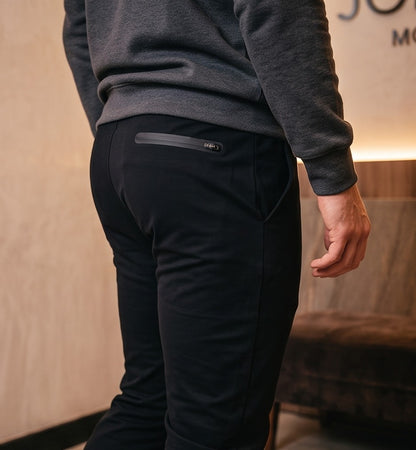 Pantalón jogger deportivo y casual para hombre de corte ajustado tipo slim fit con cintura elástica con cordón ajustable, bolsillos laterales profundos y bolsillo trasero con cremallera termosellada. Disponible en colores verde azulado, negro, blanco y granate.