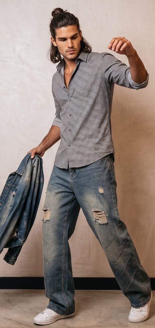 Pantalón jean ancho estilo urbano streetwear en denim 100% algodón con efecto lavado en tonos azul y negro desgastado, tiro medio-alto, cintura semielástica con botón y cremallera, roturas desgastadas en rodillas y bordados diagonales decorativos en las piernas