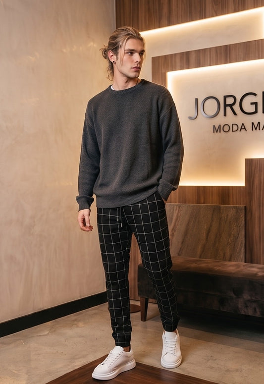Pantalones estilo jogger para hombre con un elegante patrón de cuadros tipo ventana (windowpane grid). La prenda cuenta con una cintura elástica ajustable mediante cordón, bolsillos laterales prácticos y un ajuste ceñido pero cómodo que se estrecha hacia los tobillos. Está disponible en una gama de colores que incluye azul claro, beige, azul marino, gris oscuro y negro, todos con las líneas de los cuadros en contraste blanco.