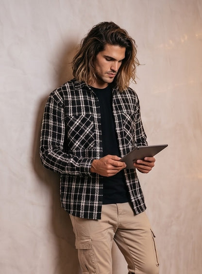 Sobrecamisa gruesa de cuadros para hombre con tejido texturizado tipo tweed en tonos blanco y negro, cuello de solapa, bolsillos frontales y cierre de botones.