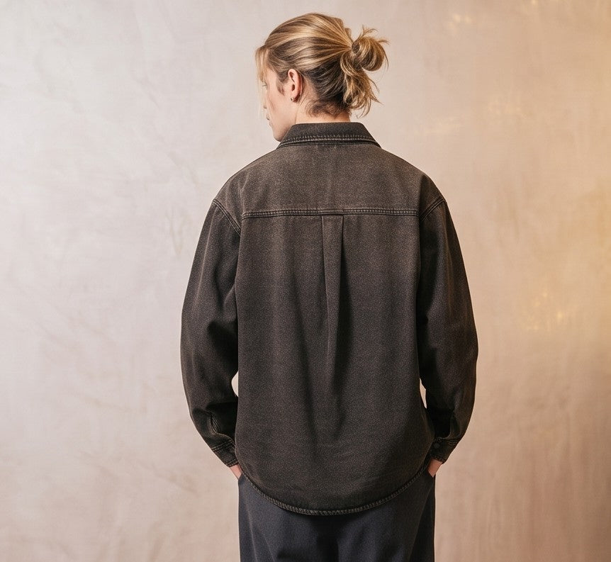 Sobrecamisa vaquera de corte holgado para hombre en tejido denim negro lavado desgastado con cuello camisero, bolsillo frontal de parche y cierre de botones.
