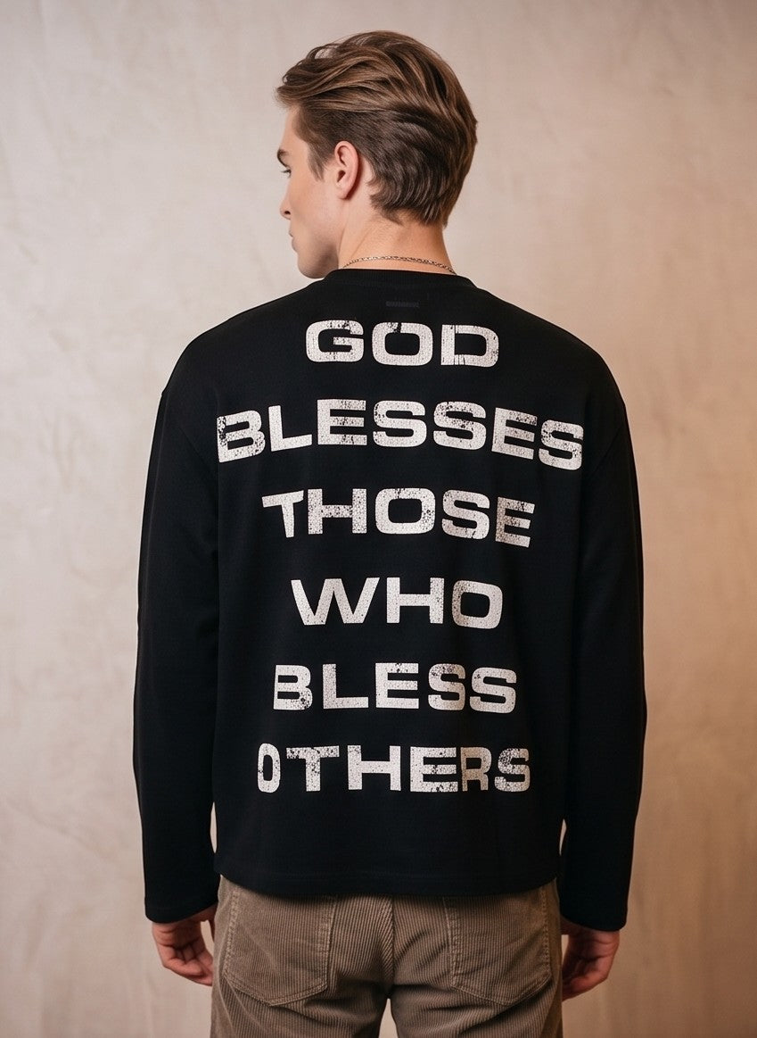 Sudadera de cuello redondo negra en corte holgado y estilo vintage urbano, con cruz roja desgastada y tipografía en el frontal, y mensaje tipográfico blanco en la espalda.