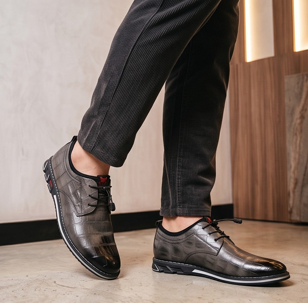 Zapatos híbridos de vestir y estilo casual para hombre con textura efecto piel de cocodrilo brillante, sistema de cordones elásticos ajustables con tanca y suela deportiva ergonómica antideslizante, disponibles en color negro, marrón café y gris degradado.