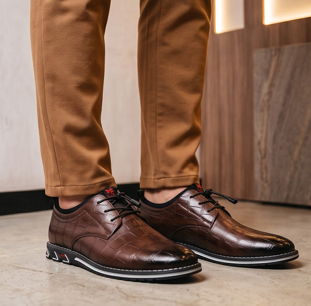 Zapatos híbridos de vestir y estilo casual para hombre con textura efecto piel de cocodrilo brillante, sistema de cordones elásticos ajustables con tanca y suela deportiva ergonómica antideslizante, disponibles en color negro, marrón café y gris degradado.