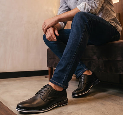 Zapatos derby híbridos de vestir para hombre en cuero sintético negro y marrón, con detalles microperforados en los laterales, costuras reforzadas al tono, cordones encerados y suela deportiva ergonómica antideslizante con ribete blanco